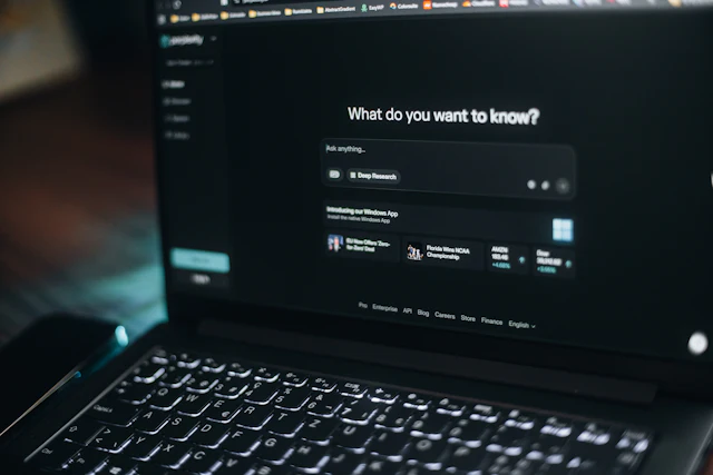 Un écran d'ordinateur affiche un assistant qui demande « What do you want to know? »
