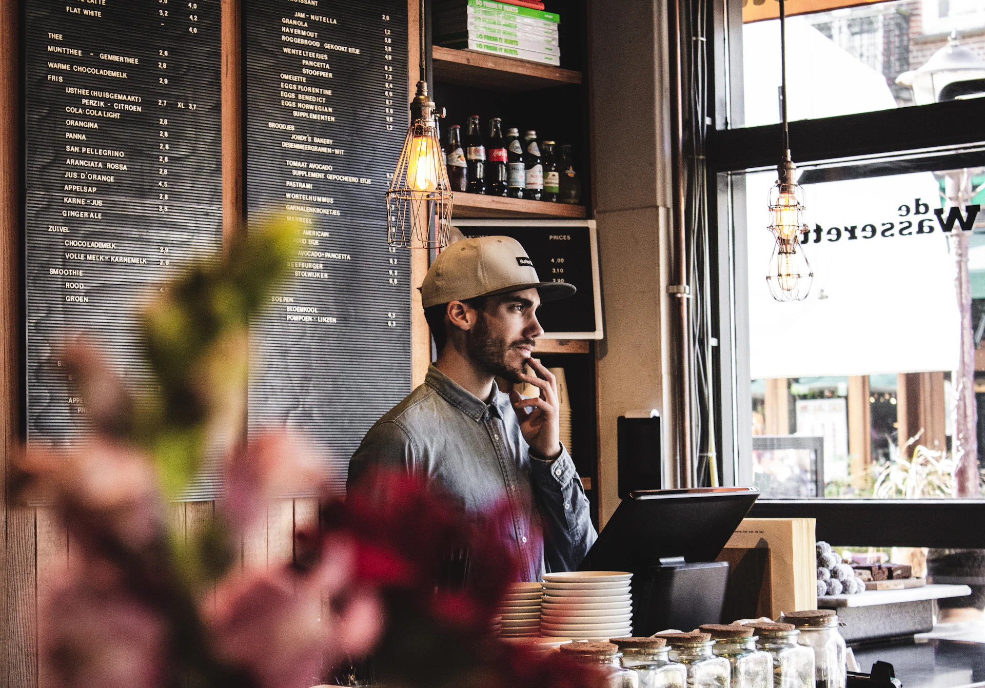 Un commerçant au comptoir de son café, au téléphone